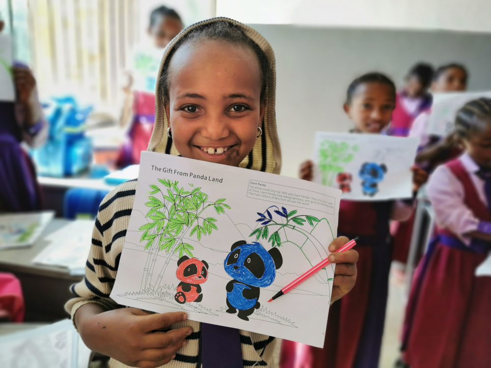 Beneficiary student of the Panda Pack Project in Ethiopia showing her drawing of pandas, 2019